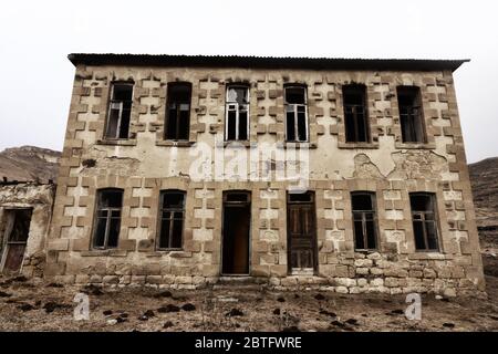 Abandoned house with stucco architraves in Caucasus mauntais like a crumbling old thing Stock Photo