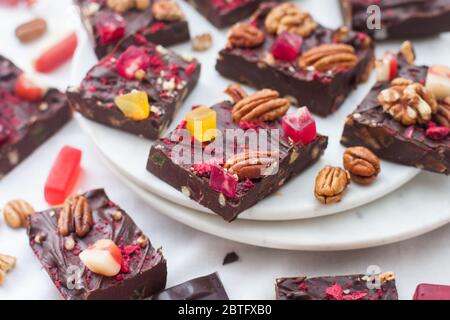 Chocolate fudge pieces with pecan nuts, dried berries and chewy sweets. Homemeade dessert Stock Photo