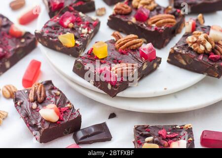 Chocolate fudge pieces with pecan nuts, dried berries and chewy sweets. Homemeade dessert Stock Photo
