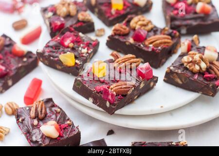 Chocolate fudge pieces with pecan nuts, dried berries and chewy sweets. Homemeade dessert Stock Photo