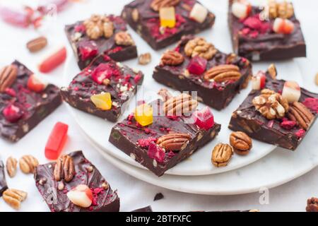 Chocolate fudge pieces with pecan nuts, dried berries and chewy sweets. Homemeade dessert Stock Photo