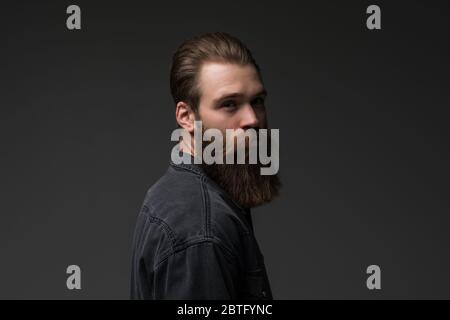 Handsome bearded young man isolated on gray background Stock Photo