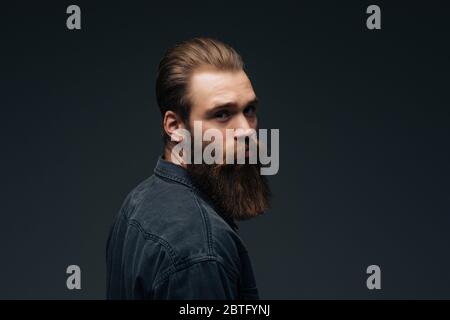 Handsome bearded young man isolated on gray background Stock Photo