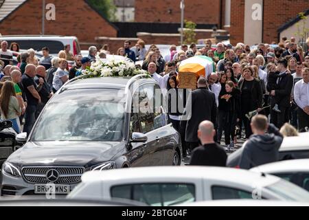 Lenadoon, West Belfast, Northern Ireland. 25th May, 2020. Mourners gather outside the home of Kieran Wylie (57) who was shot dead in Lenadoon, West Belfast as his remains are carried out of his home. Mr Wylie was believed to have been murdered over informing on Dissident Terrorist Groups in Northern Ireland Credit: Conor Kinahan/Alamy Live News Stock Photo