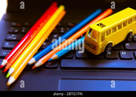Color pencils and toy school bus on the keyboard on the keyboard. Back to school concept Stock Photo