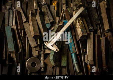 rusted steel tools and caliper on the table in metal factory workshop Stock Photo