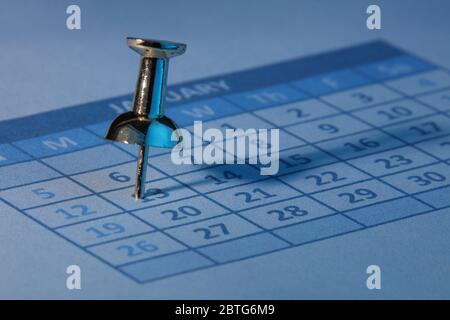 Push pin in calendar with blue light Stock Photo