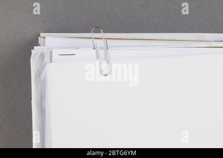 Bundle of work papers with paperclip on grey background Stock Photo