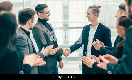 business partners shaking hands to the applause of the business team Stock Photo