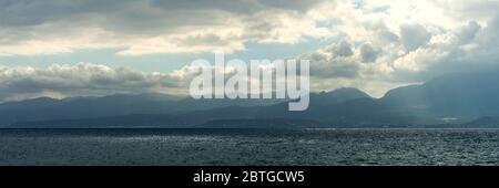 Stormy clouds over the coastal rocks. Dramatic sky over the sea. Stock Photo