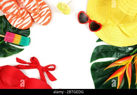 Summer vacation resort theme flat lay with sunhat, ice creams, swim suit, sunglasses, tropical leaves and flowers in bright colors. Modern stylish cre Stock Photo