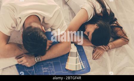 tired young couple is sleeping on the floor in a new apartment. Stock Photo