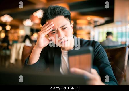 young Business man  Working On Laptop and mobile phone In Coffee Shop Stock Photo