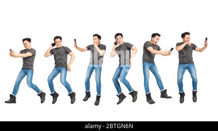 excited young man jumping and using mobile phone concepts Stock Photo