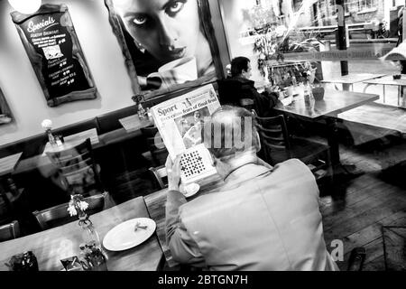 man reading sports page in a cafe Stock Photo