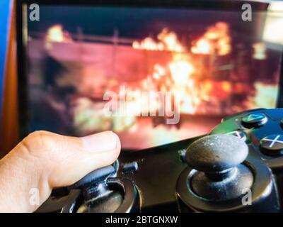 Video game controller closeup from console against monitor screen Stock Photo