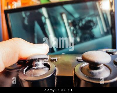 Video game controller closeup from console against monitor screen Stock Photo