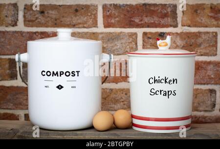 recycle kitchen food waste compost container and chicken scraps container on kitchen counter top, sustainable living home farm victory garden concept Stock Photo