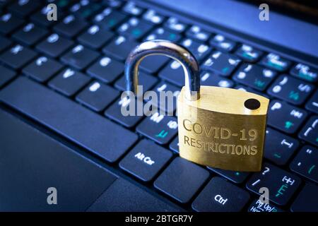 COVID-19 coronavirus lockdown restrictions ease concept illustrated by unlocked padlock on laptop. Stock Photo
