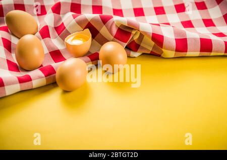 Beautiful fresh brown chicken eggs on yellow background with copy space. Stock Photo