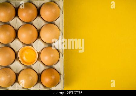 Beautiful fresh brown chicken eggs on yellow background with copy space. Stock Photo