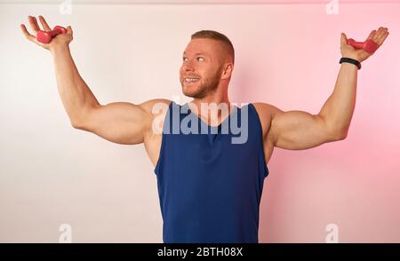 a man with small dumbbells on a light background Stock Photo