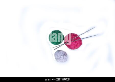 clews of different colours and knitting needles isolated on white background flat lay. Image contains copy space Stock Photo