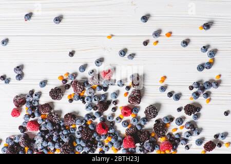 Close up of frozen mixed berries on white wooden background. Stock Photo