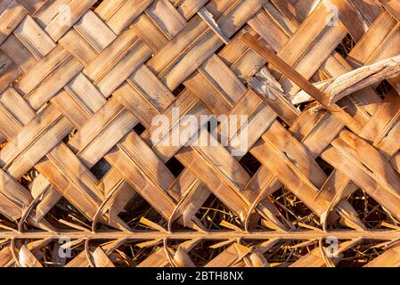 Detail of an Asian house roof made from coconut palm leaf. Natural protection from sun and rain. Dry palm leaf for background. Stock Photo