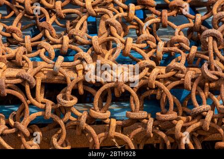 rusty old chains close-up corroded fishing gear on a quayside. Stock Photo