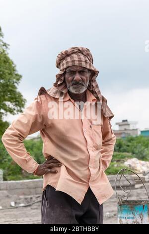 Portrait of a man working at the construction site of bridge, Ghaziabad, India Stock Photo