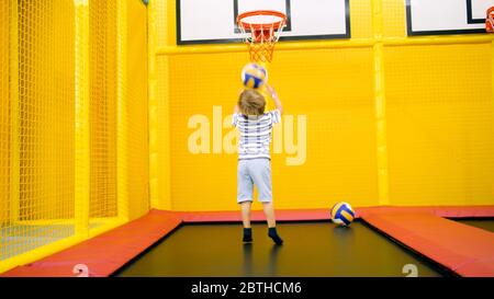 Cute little boy playing in basketball on playground at amusement park Stock Photo