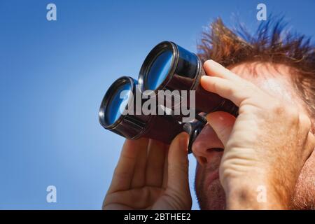 Outdoor type man looking through binoculars Stock Photo