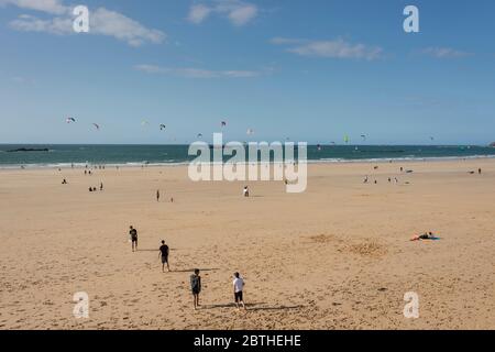 People flying kites on sandy beach, St Malo, Brittany, France Stock Photo