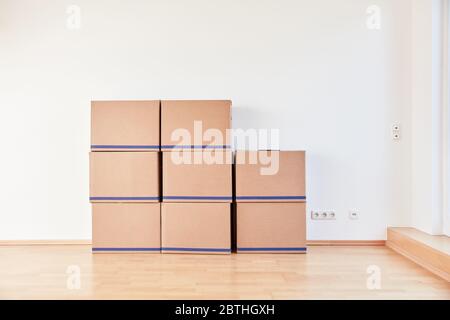 Many moving boxes stacked on the wall when moving to a new apartment Stock Photo