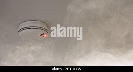 Smoke detector on the ceiling reports smoke and fire as a fire protection concept Stock Photo