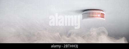 Warning smoke detector in case of fire alarm as fire protection panorama header Stock Photo