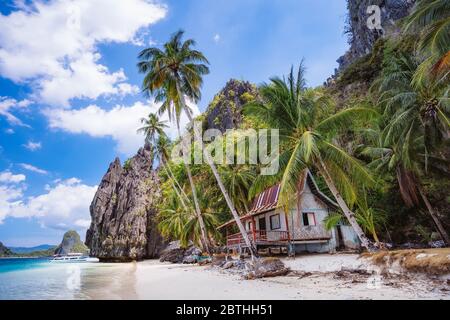 tropical hut under palm trees on Ipil Beach at Pinagbuyutan Island. El Nido, Palawan, Philippines Stock Photo