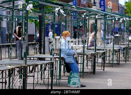 Loughborough, Leicestershire, UK. 26th May 2020. A woman rests on an empty market stall after Boris Johnson announced outdoor markets will be able to reopen in England from 1st June, during the coronavirus pandemic lockdown. Credit Darren Staples/Alamy Live News. Stock Photo