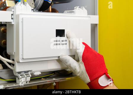 Repair of a gas boiler, setting up and servicing by a service department. Adjustment of gas boiler at domestic home. home repairs service concept. Stock Photo