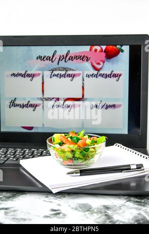 A meal plan for a week. Bowl with vegetable salad in the workplace near the  computer. Lunch in the office during a break between work Stock Photo -  Alamy
