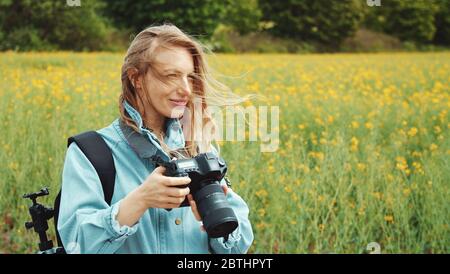 Photographer holding camera looking around Stock Photo