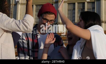 Multicultural cheerful friends giving high five gesture feel exc Stock Photo