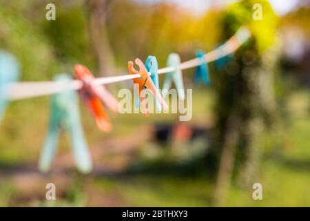 Orange and blue cloth clip on clothes line, blur nature green background Stock Photo