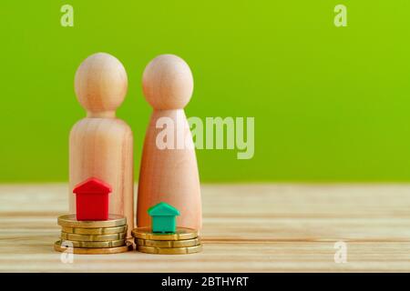 Wooden family with toy house and stack of coins. Savings for house purchase concept Stock Photo