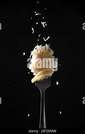 Fork with Spaghetti Sprinkled Cheese and Pepper on Dark Background. Cacio e Pepe - Italian Pasta. Stock Photo