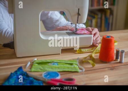 Close Up of a Womans Hands on a Sewing Machine Making Homemade Face Masks Stock Photo