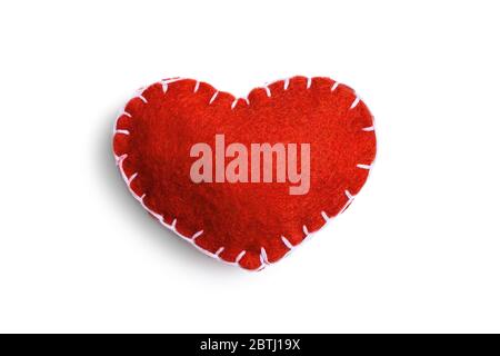 Handmade red heart made of felt stitched with white thread isolated on a white background. Stock Photo