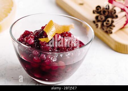 Thanksgiving cranberry sauce in glass bowl with fresh citrus fruits Stock Photo