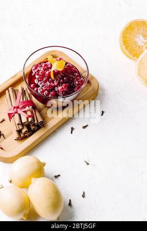 Thanksgiving cranberry sauce in glass bowl with fresh citrus fruits Stock Photo